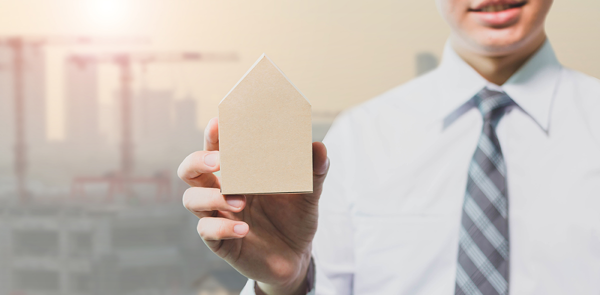 Businessman holding house model - Real estate concept
