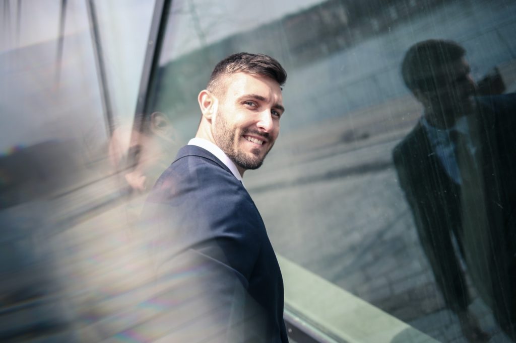 Homem com terno olhando para trás e sorrindo