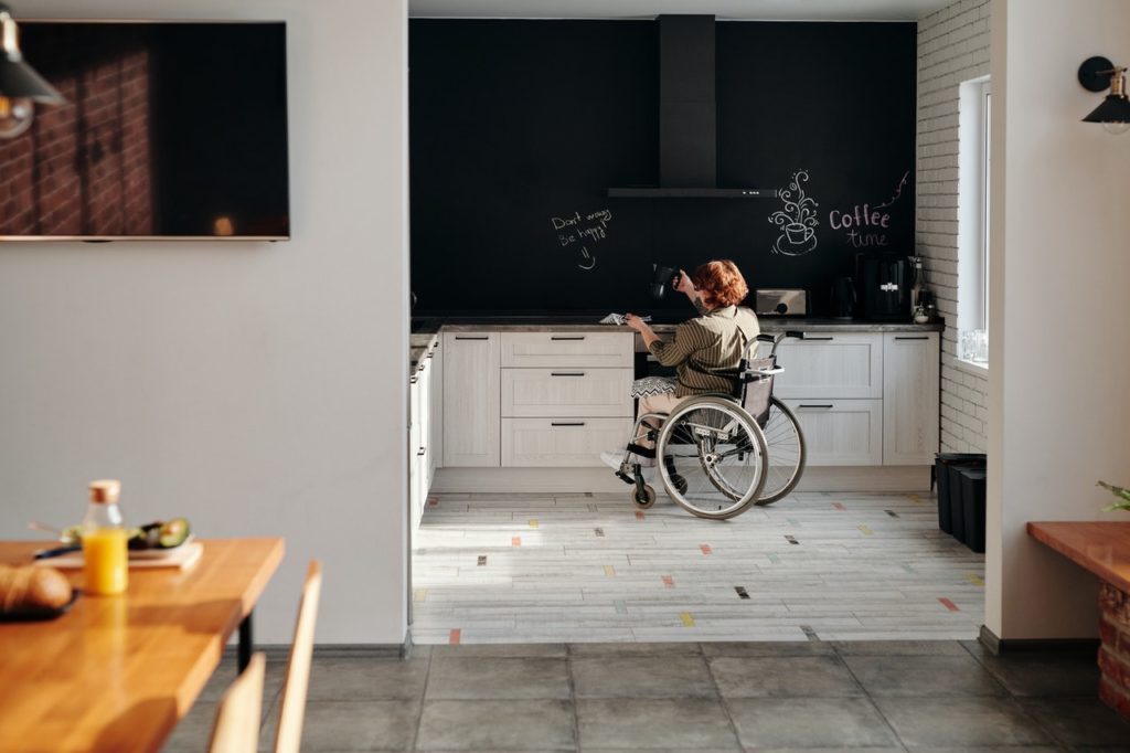 pessoa deficiente em cadeira de rodas em cozinha adaptada para acessibilidade