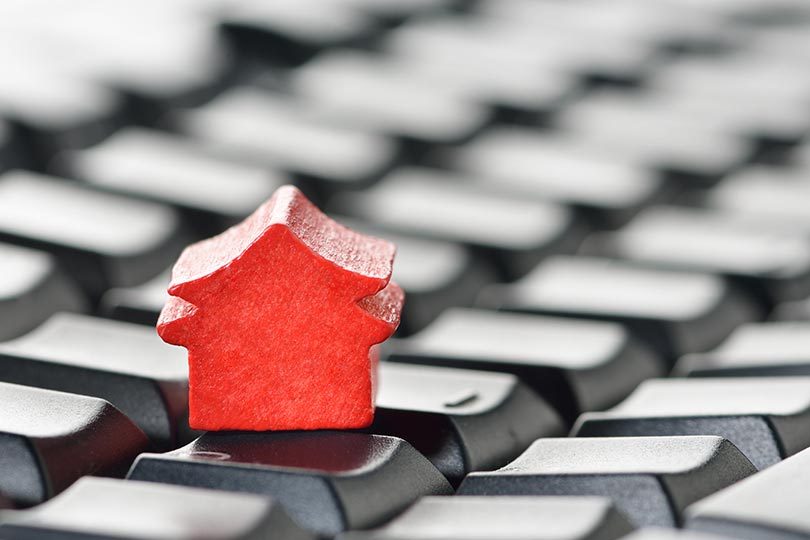 casinha de madeira vermelha em cima de teclado de computador