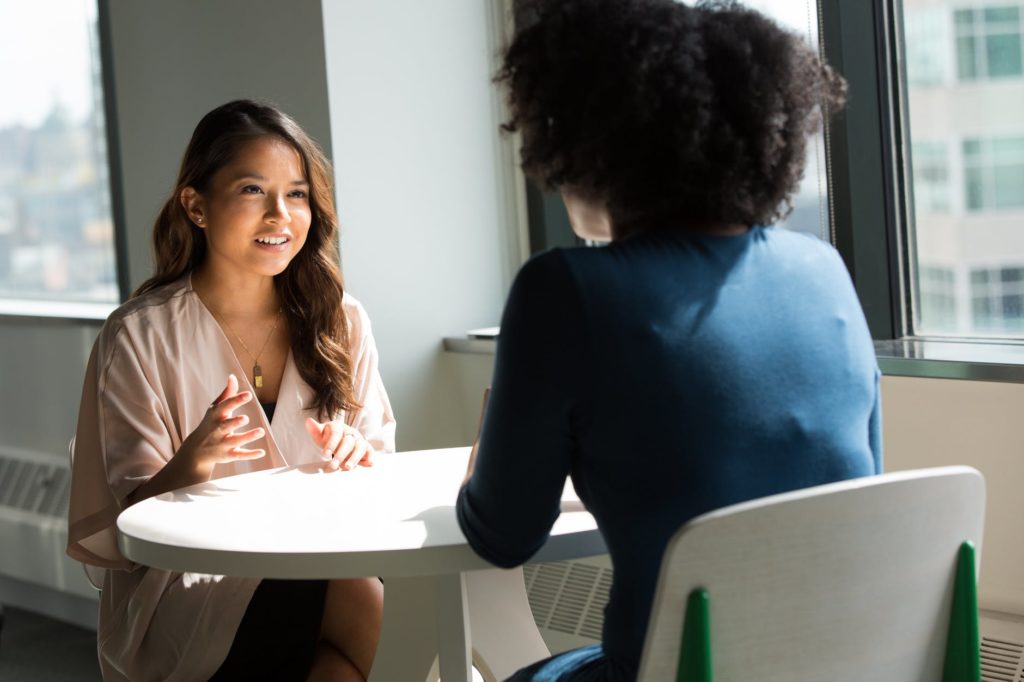 Duas mulheres conversando em uma mesa